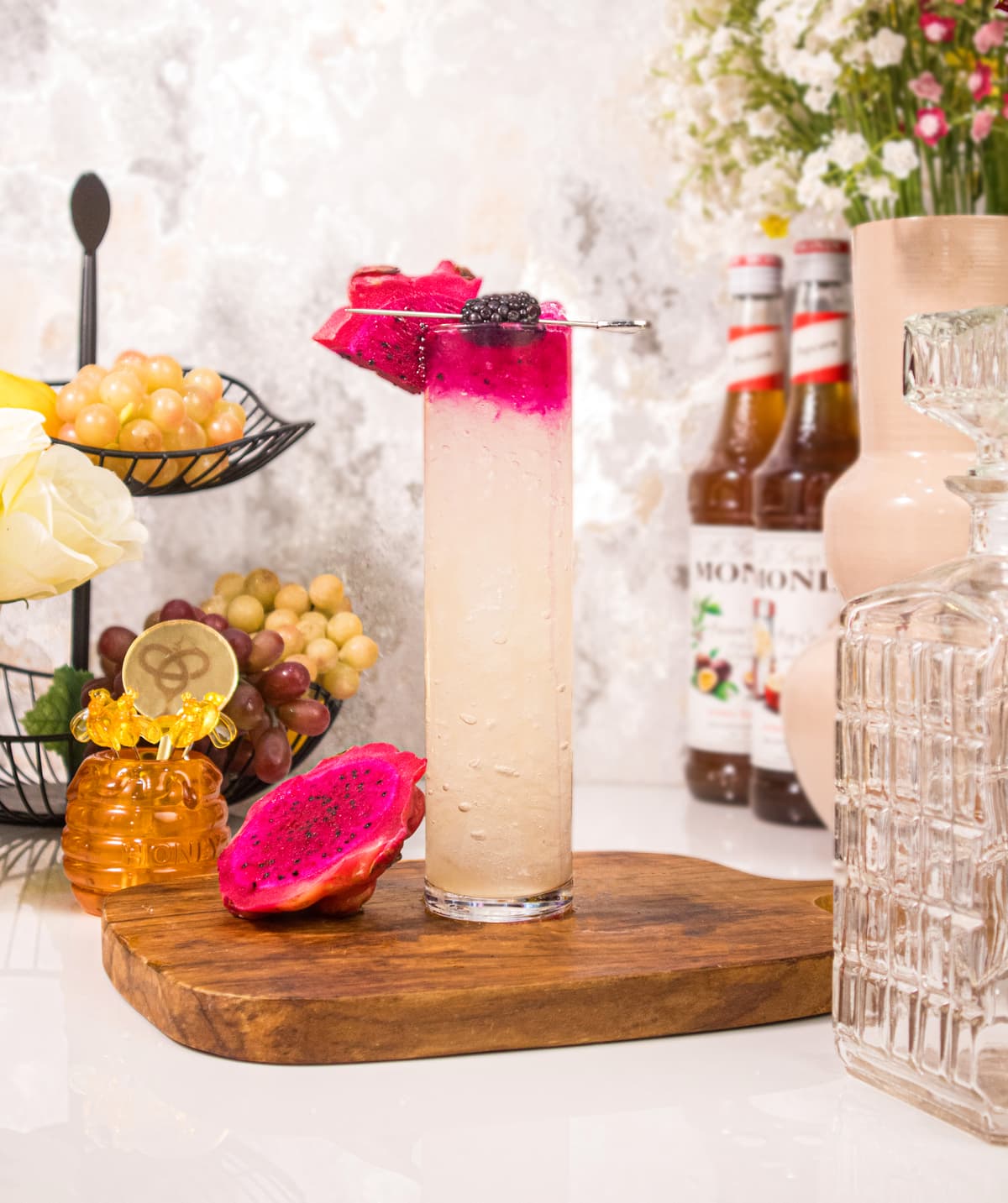 Tall Dragon Fruit Fizz — a fizzy base layered under a bright magenta puree float, finished with fresh dragon fruit and blackberry.
