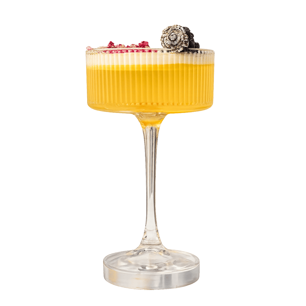 Ribbed coupe cocktail with berry and floral garnish